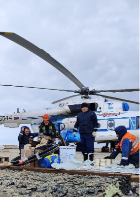 Команда у вертолёта готовит груз